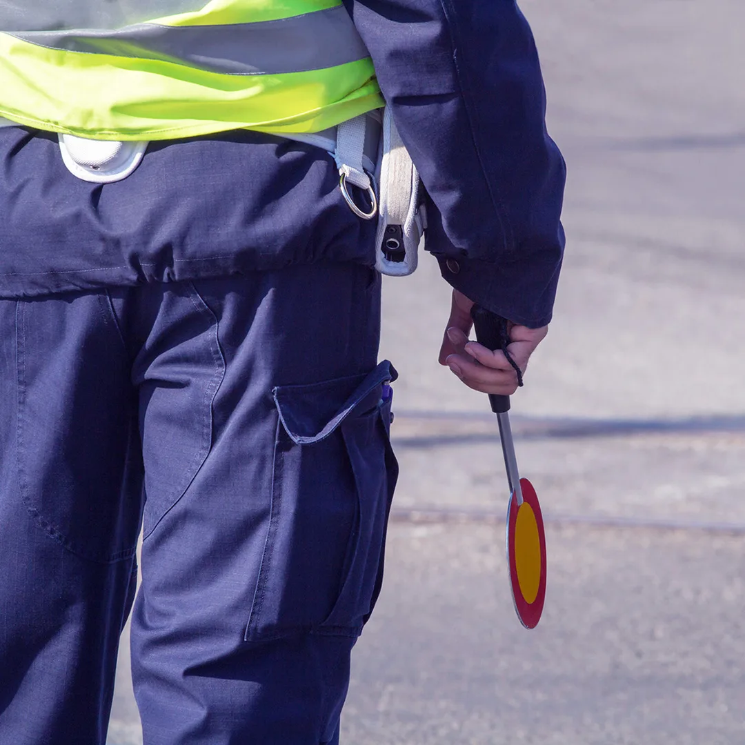 Foretakskontroll hos Volmax Kontrollør med refleksvest holder stoppskilt, som illustrerer Volmax sin kompetanse innen foretakskontroll og oppfølging av krav til sikker og forskriftsmessig transport.