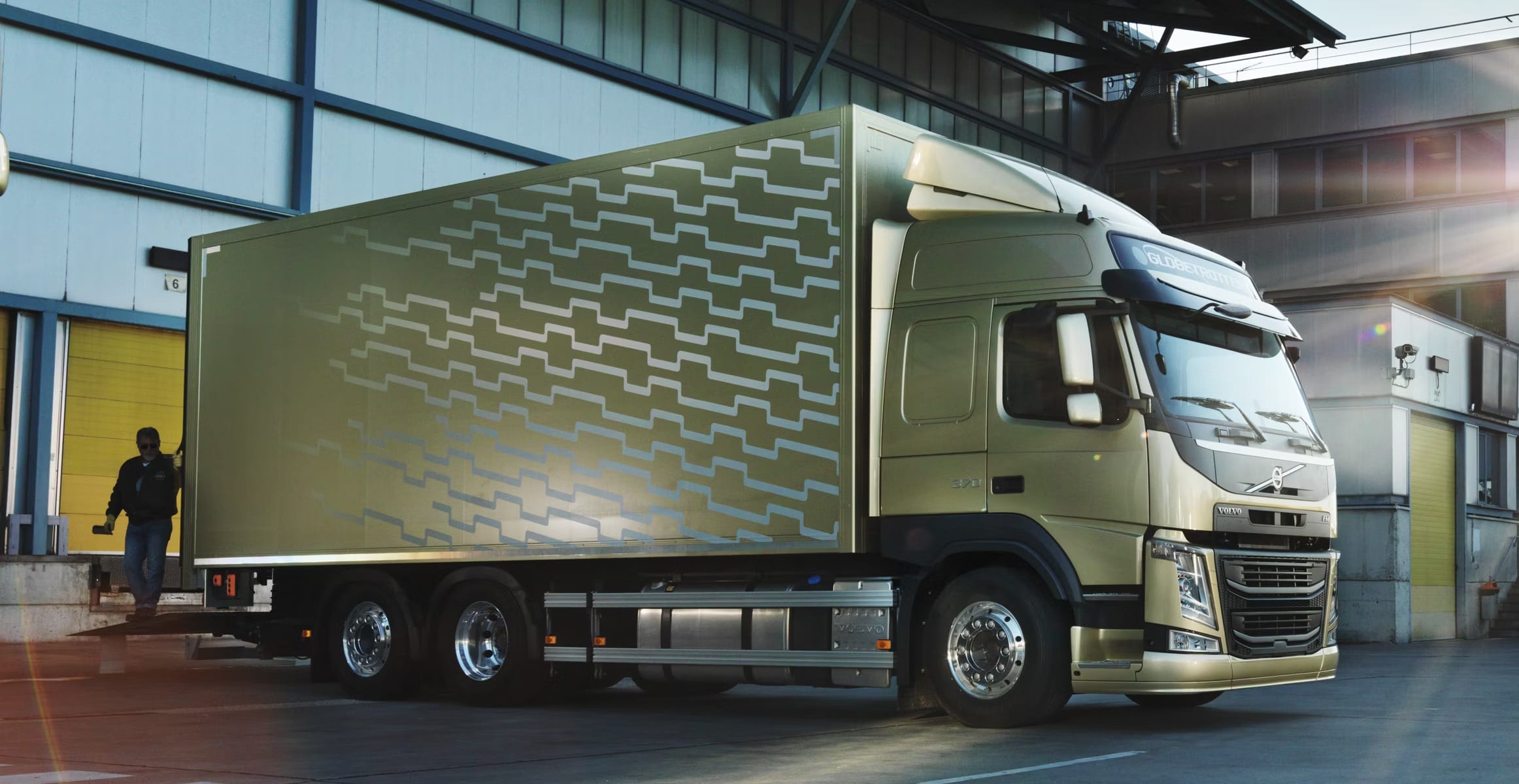 Effektiv transportløsning med Volmax Volvo Globetrotter lastebil ved lasteområde, som illustrerer Volmax sin kompetanse innen service, drift og oppfølging av tunge kjøretøy.